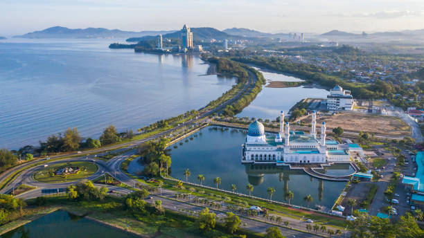 Aerial view of the floating Kota Kinabalu City Mosque on a lagoon with the coastline and city skyline in the background, Sabah, Malaysia