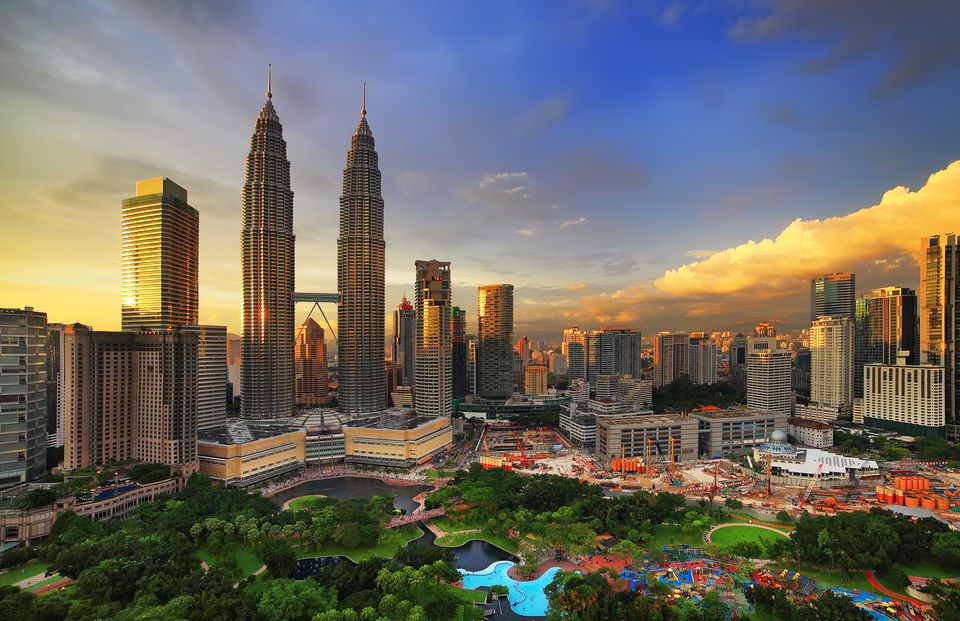 Petronas Twin Towers rising above the Kuala Lumpur skyline at golden sunset, with KLCC Park in the foreground, Malaysia